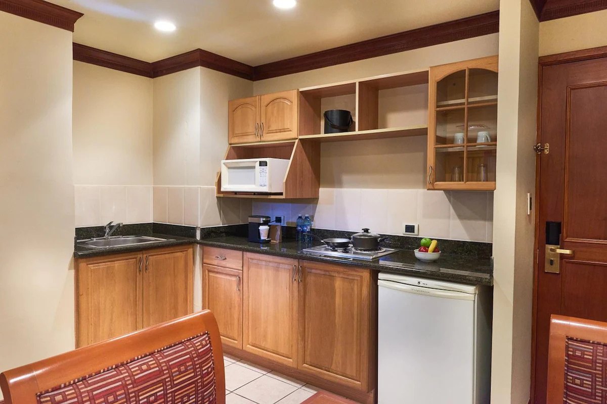 Cocina equipada de una suite con microondas, refrigerador y alacena