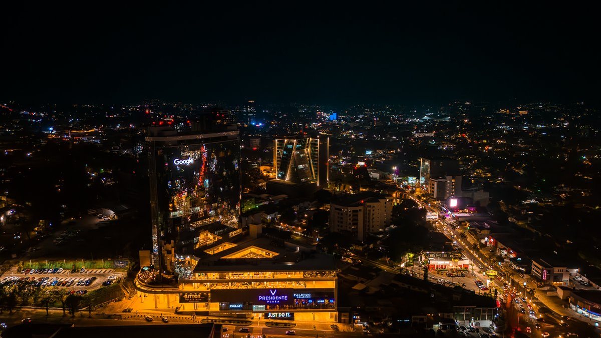 Vista aérea nocturna de la Zona Rosa de San Salvador con las torres iluminadas y el Boulevard del Hipódromo
